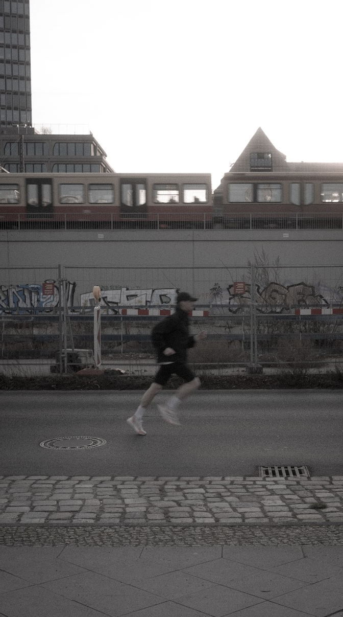 Colly, English-speaking running coach, running a Berlin street by the S-Bahn